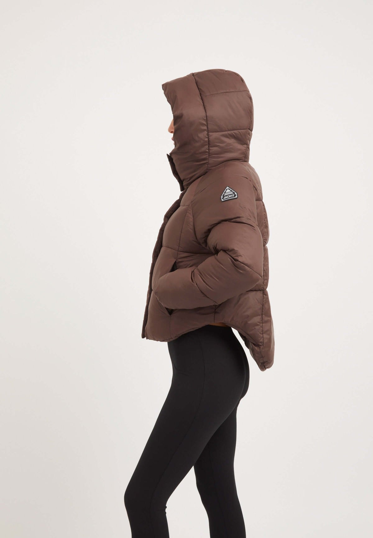 Short puffer jacket women in mid brown with adjustable hood and cropped cut for a modern silhouette.