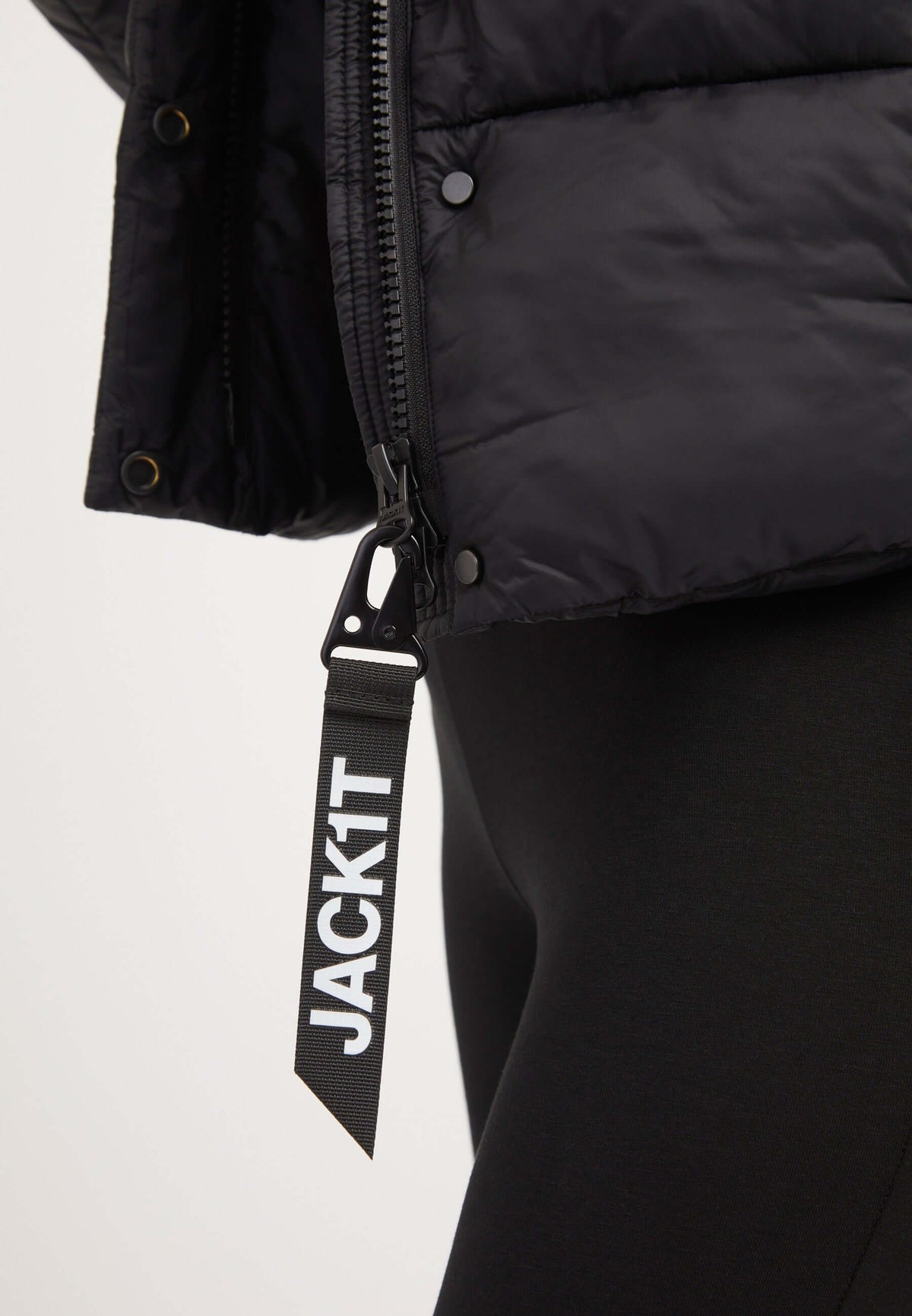 Detail of Cloud Crop Jacket Black showing zipper and JACK1T tag, highlighting features of womens short puffer jacket.
