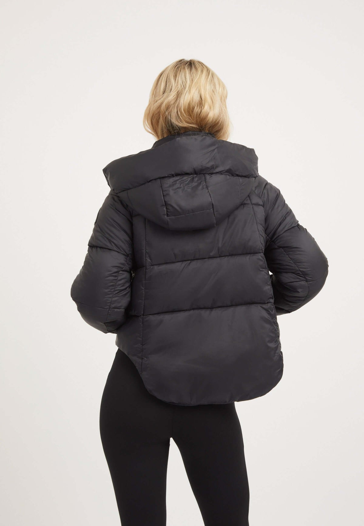 Back view of womens short puffer jacket in black with cropped cut and adjustable hood.