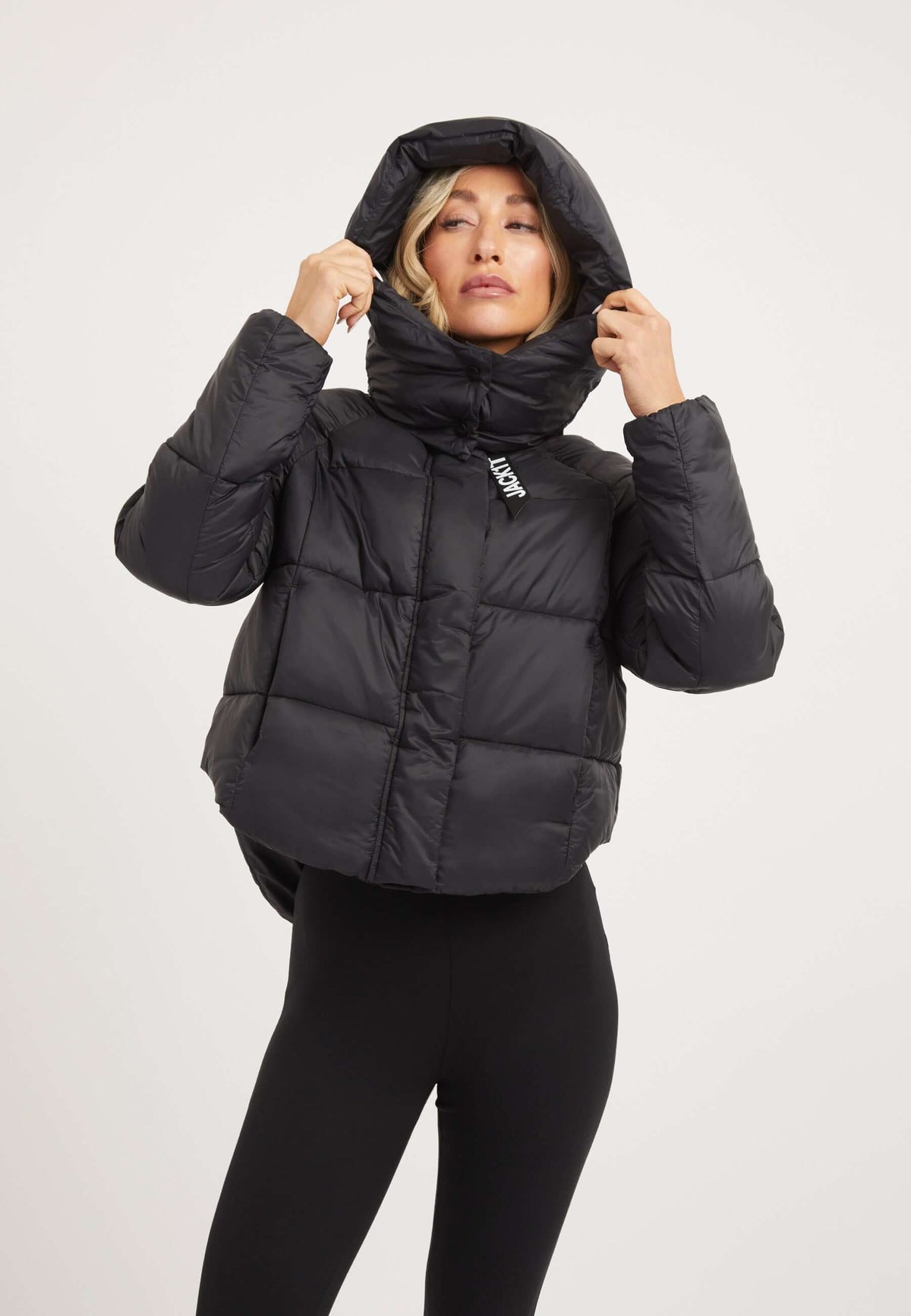 Womens short puffer jacket in black with adjustable hood and modern cropped cut.