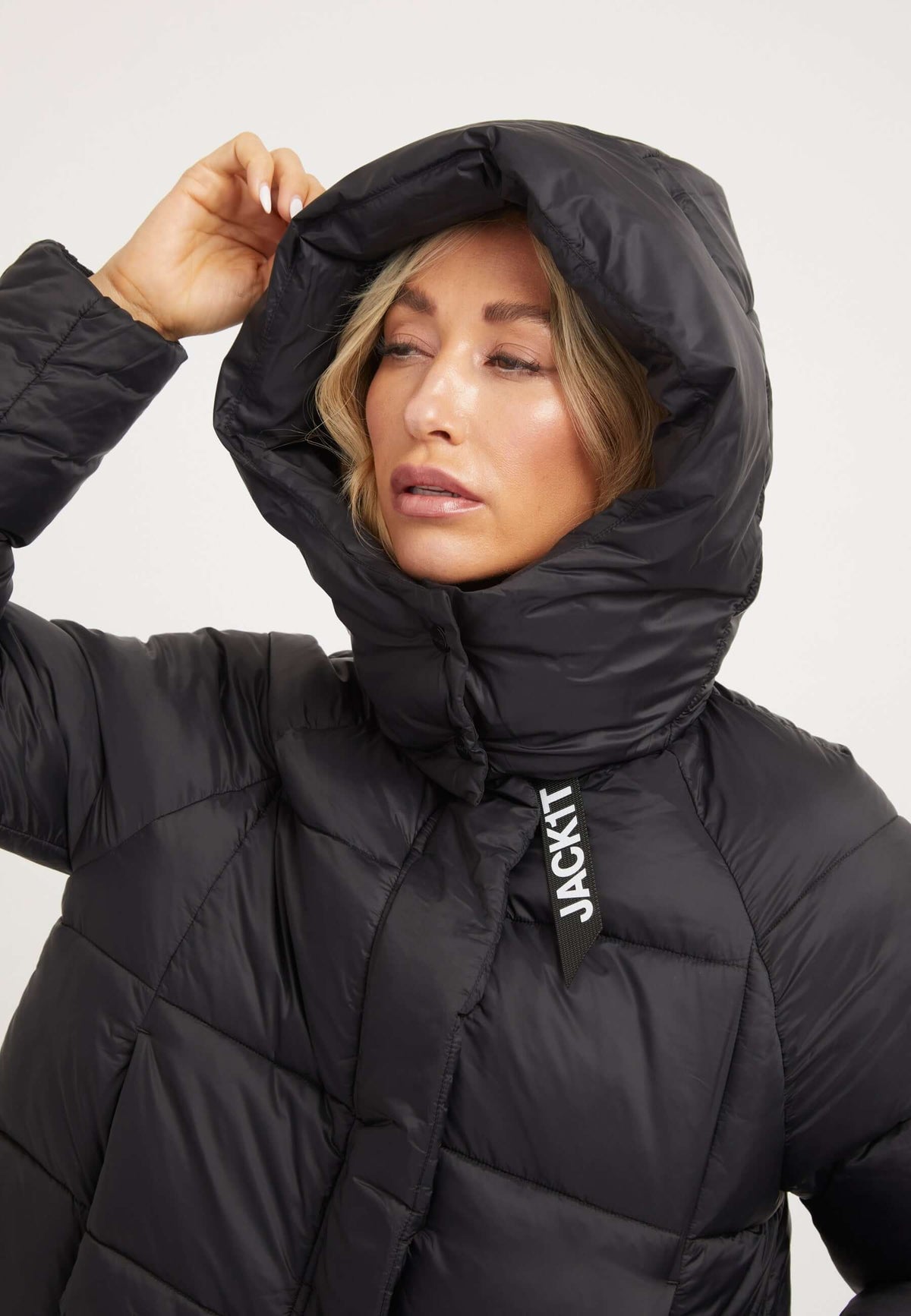 Model wearing a black Cloud Crop Jacket, showcasing the adjustable hood and modern cropped cut, perfect womens short puffer jacket.