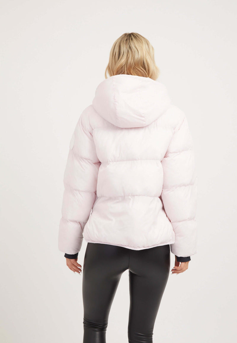 Back view of a woman wearing a soft pink Helio Crop Duvet Jacket, a stylish short puffer jacket women.