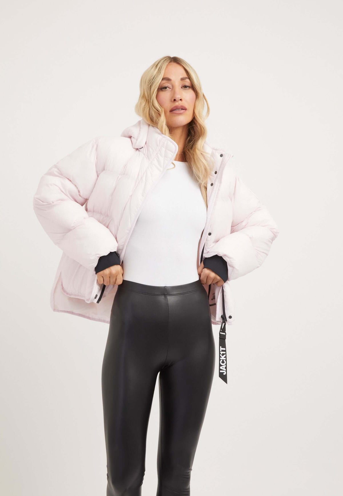 Model wearing Helio Crop Duvet Jacket in soft pink, showcasing short puffer jacket women style and lightweight design.