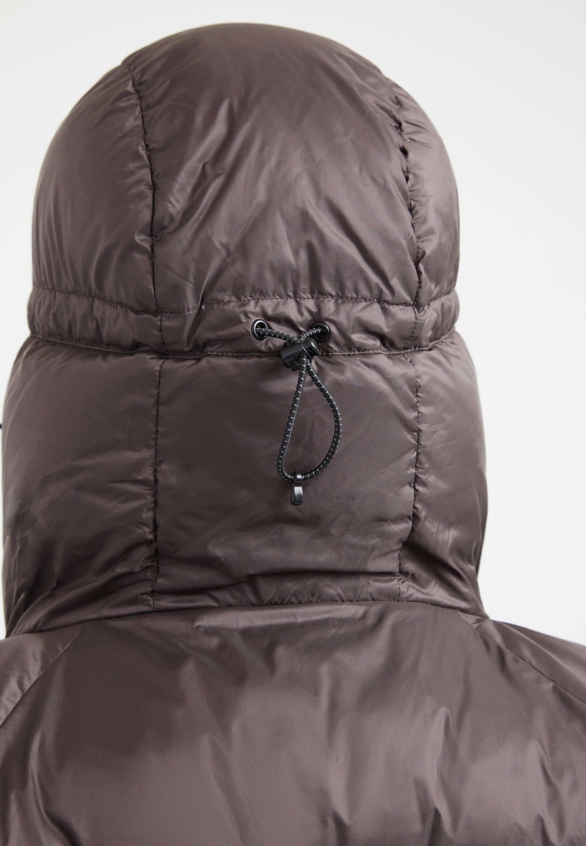 Back view of oversized puffer brown jacket with adjustable hood and durable fabric.