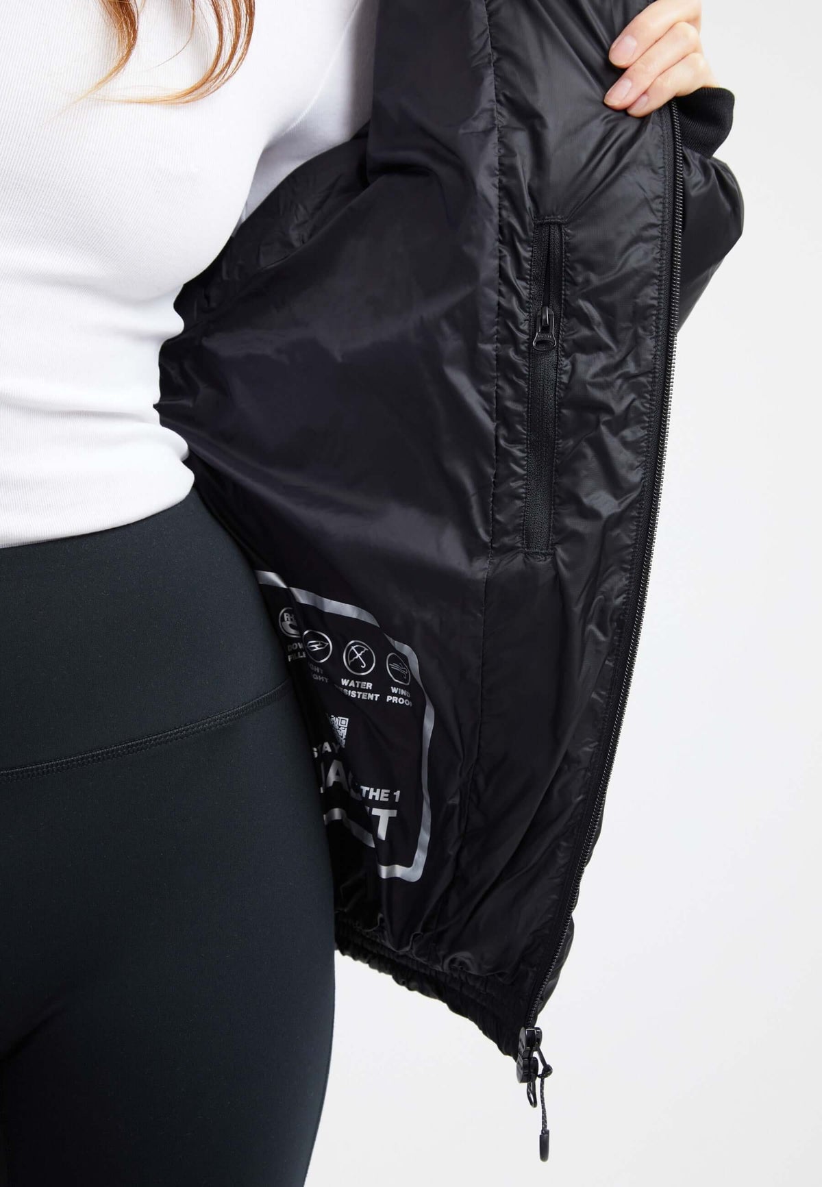Inside view of an oversized puffer black jacket showcasing the sleek fabric and detailing.