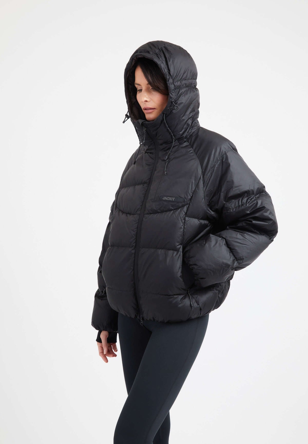 Model wearing an oversized puffer black jacket with a hood and durable fabric for warmth and style.