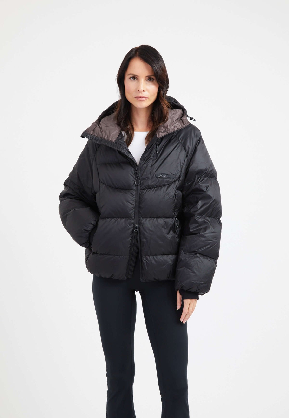 Model wearing oversized puffer black jacket with hood, showcasing its modern silhouette and durable fabric.