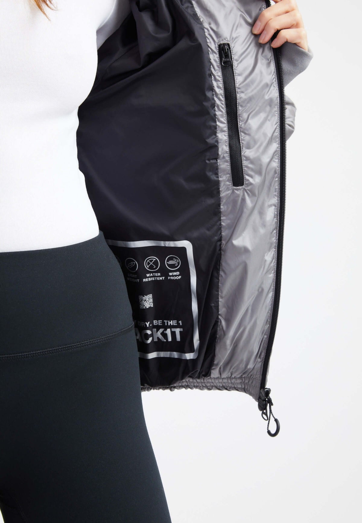 Inside view of oversized puffer grey jacket showcasing its tag and interior design details.