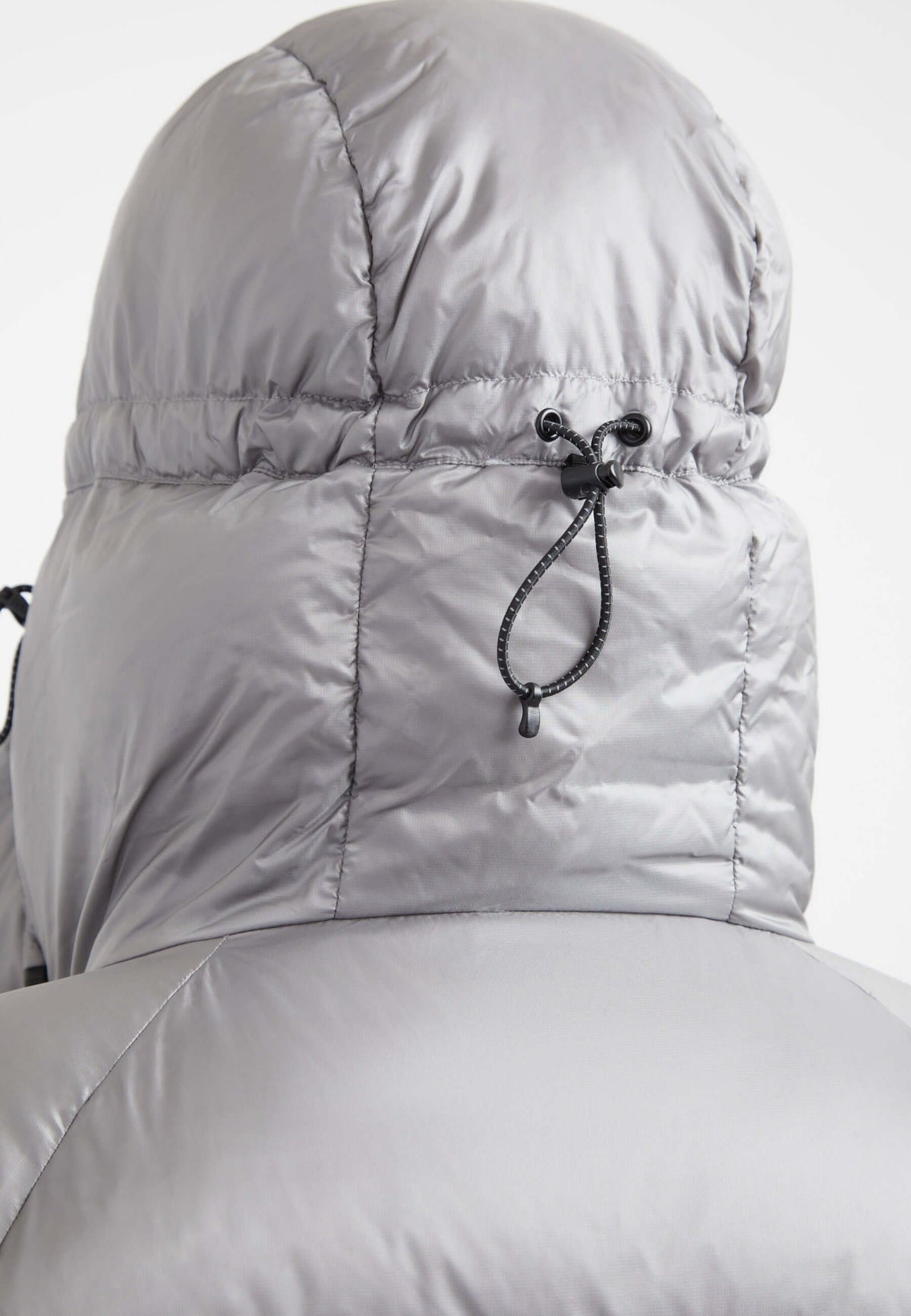 Close-up of the adjustable hood on an oversized puffer grey jacket showcasing high-quality material.