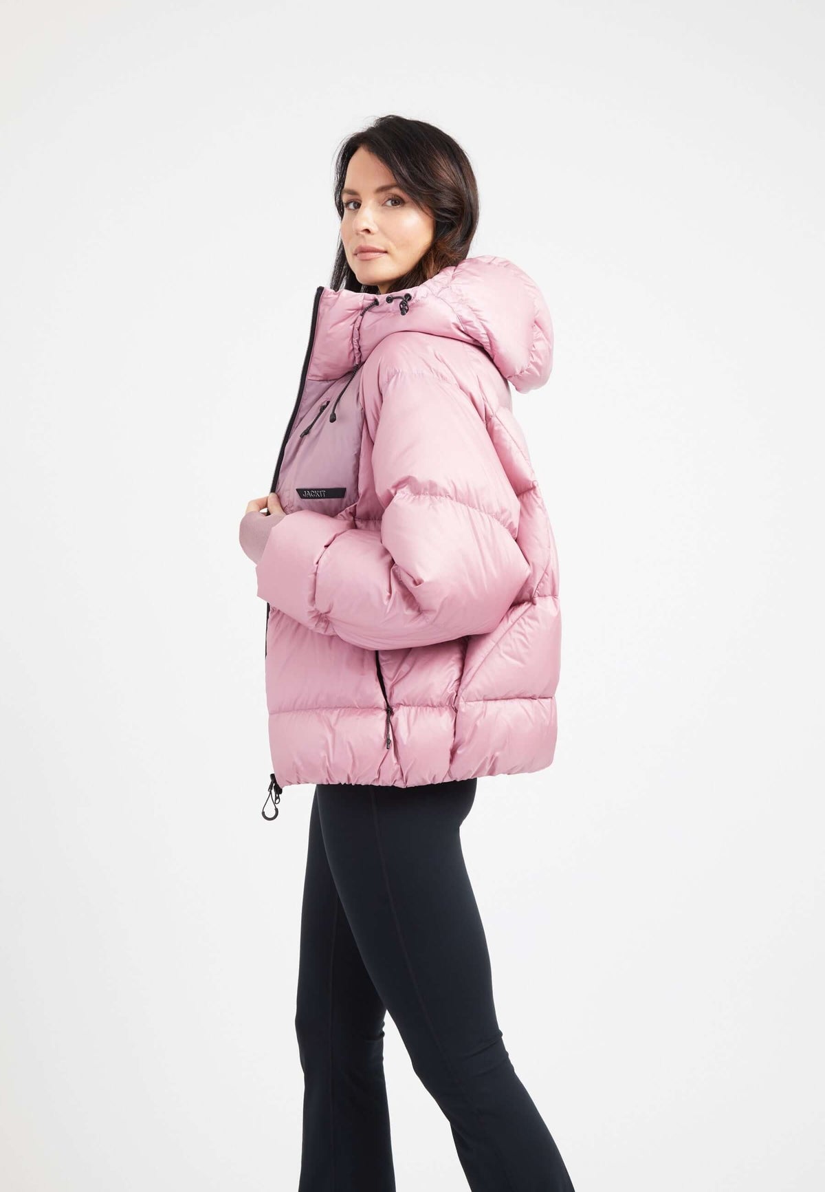 Model wearing an oversized puffer pink jacket with an adjustable hood and fleece lined pockets.