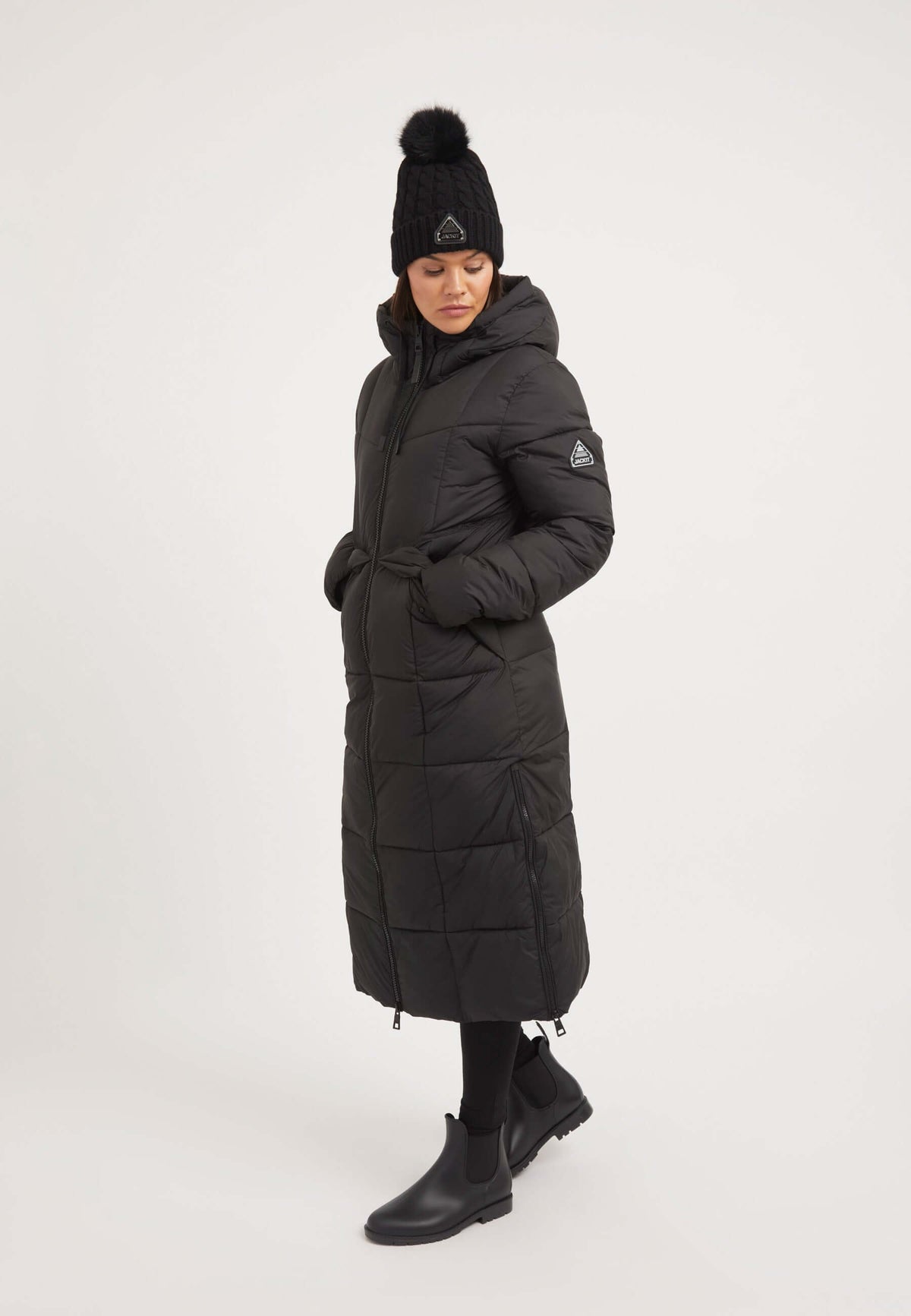Model wearing a Black Star Ex-long Puffer Matt Coat Black, showcasing the extra long puffer coat with adjustable hood.