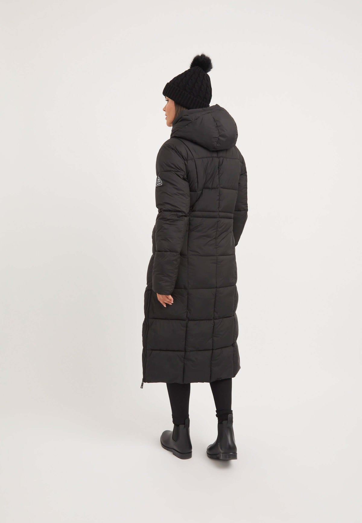Model wearing a Black Star Ex-long Puffer Matt Coat Black, showcasing the back view of the extra long puffer coat.