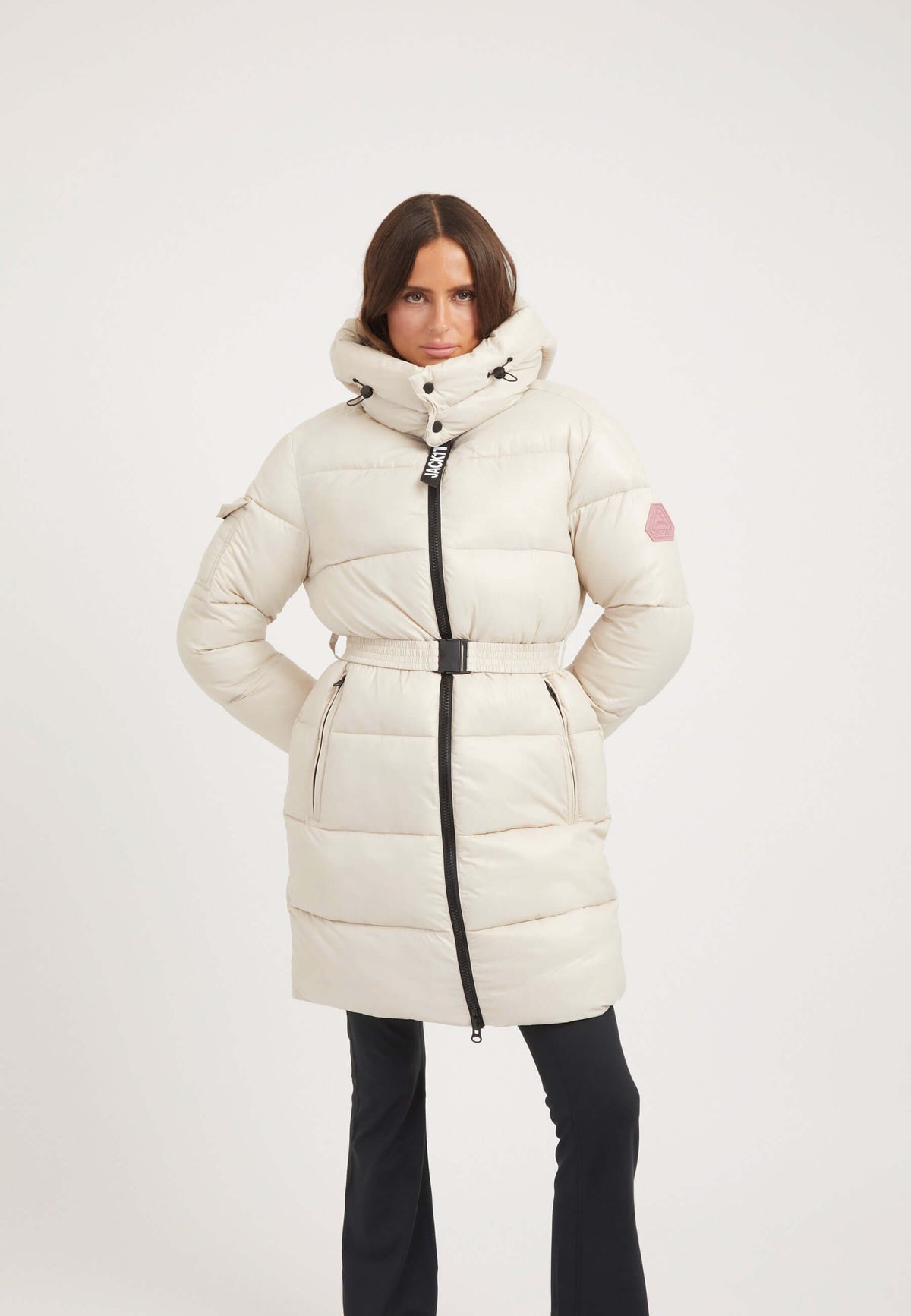 Model wearing EZ Belted Coat Stone, a womens belted puffer coat with a tapered design and removable belt.