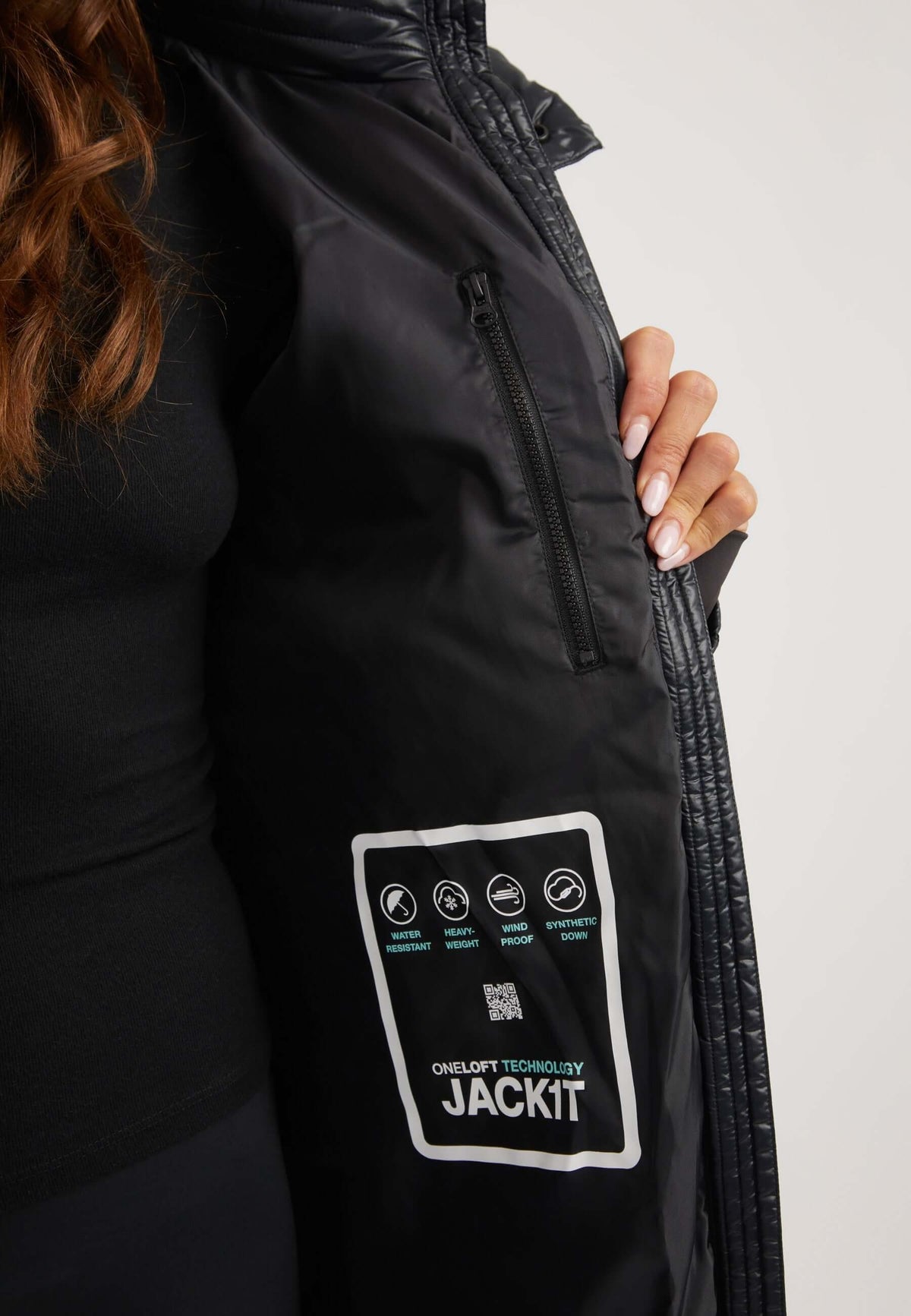 Model showcasing inside of womens belted coat black with ONELOFT technology label and zip pocket.