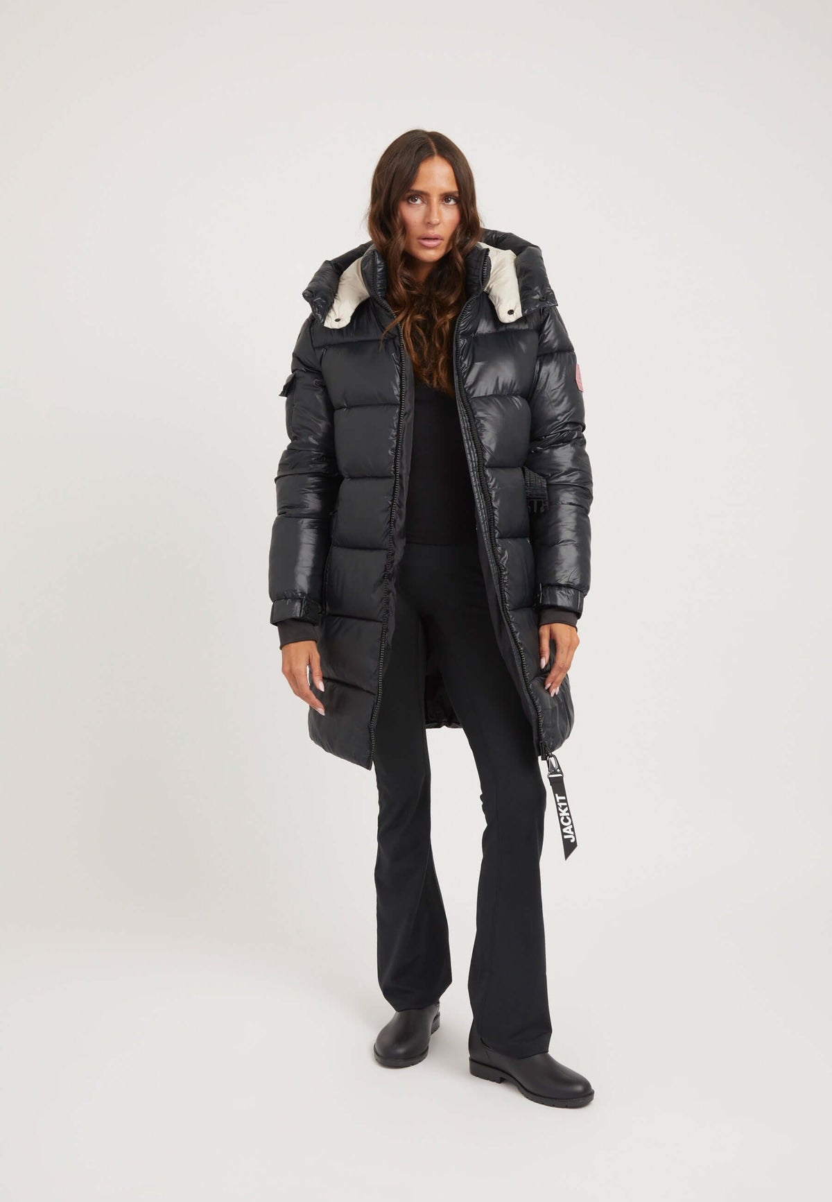 Model wearing a womens belted coat black with a tapered fit, removable belt, and Grown-on hood.