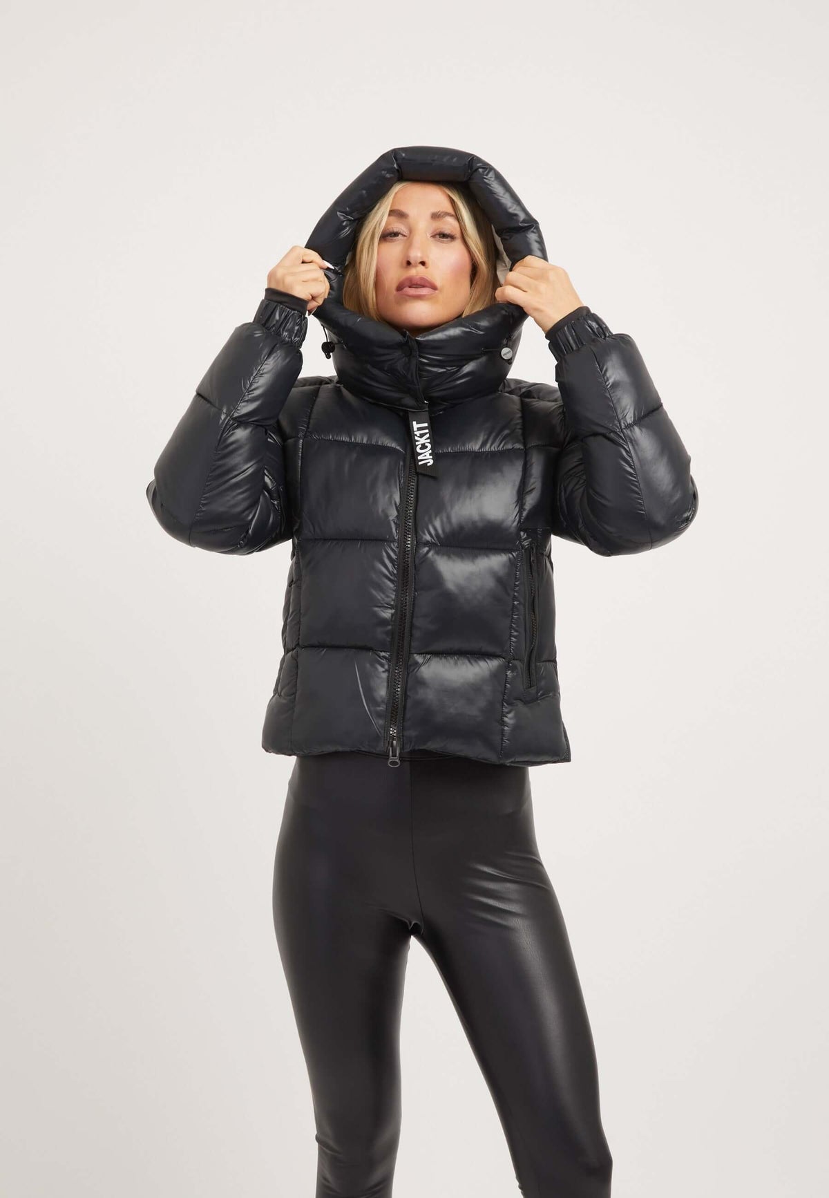 Model wearing the EZ Box Crop Jacket Black, a stylish short puffer jacket women, with a hood and sleek design.