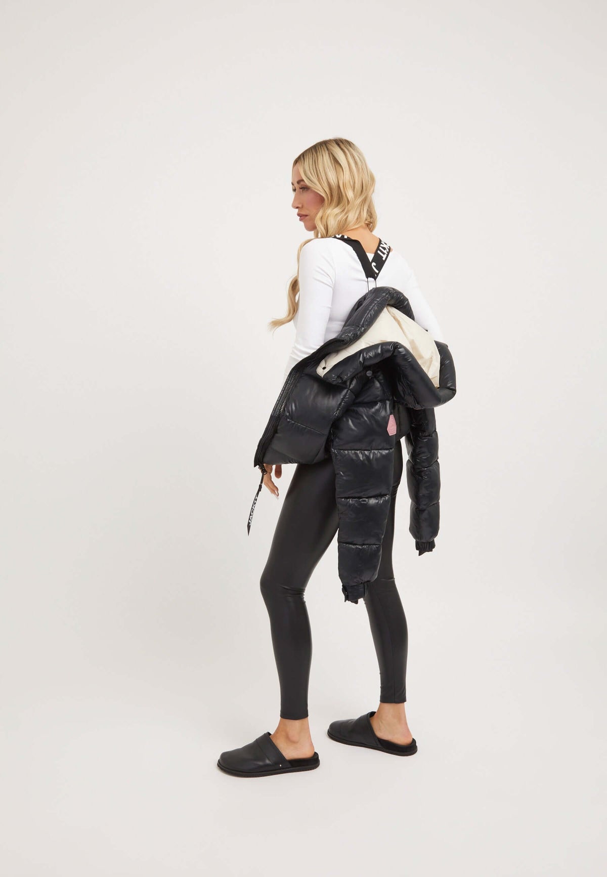 Model wearing the EZ Box Crop Jacket Black stylishly over a white top and black leggings, showcasing short puffer jacket women.