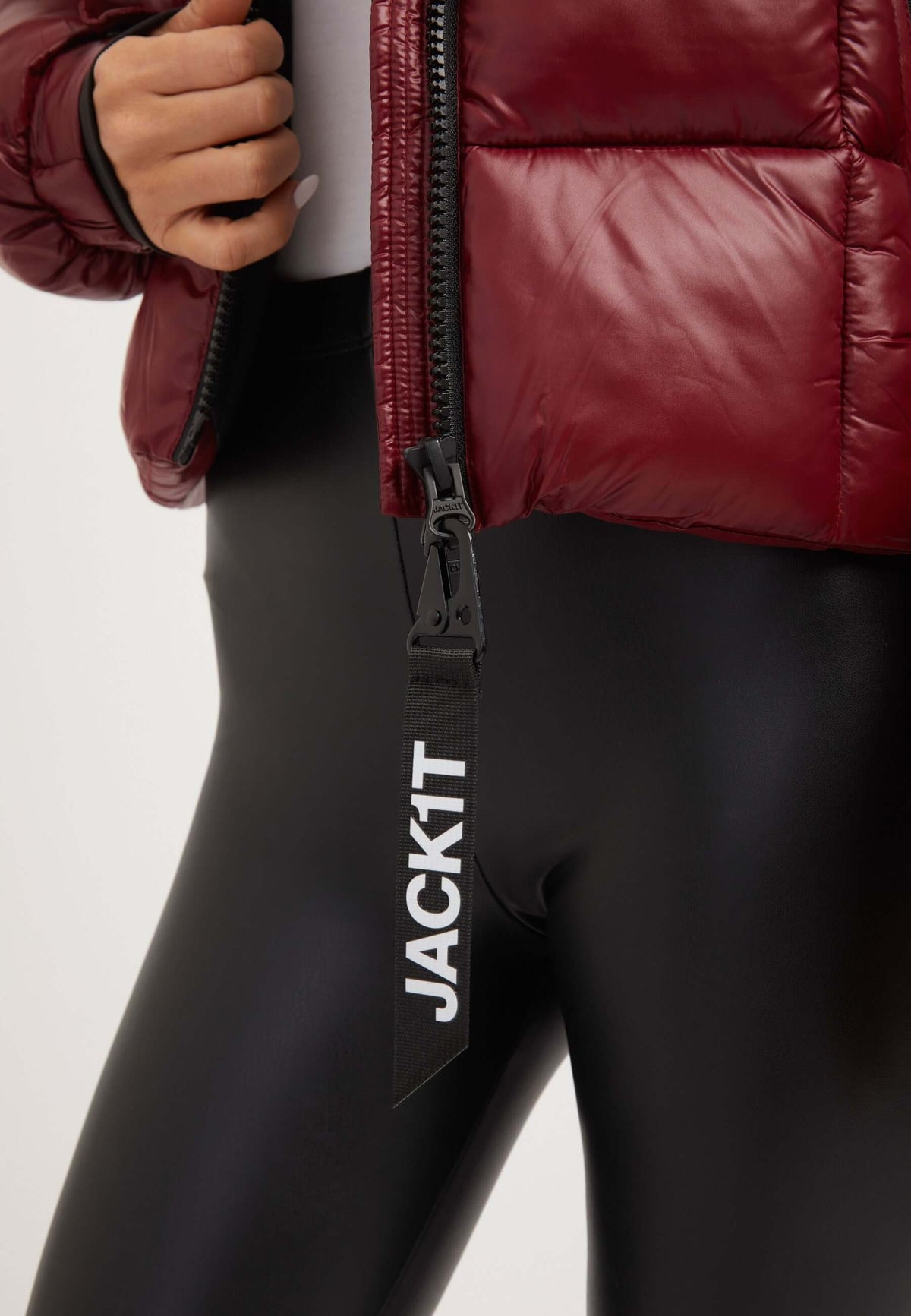 Short puffer jacket women in dark cranberry color paired with black leggings, showcasing zipper detail.