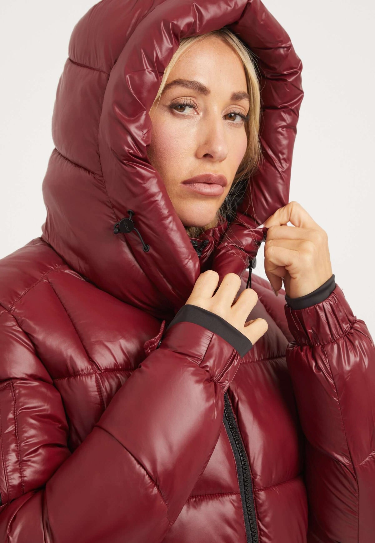 close-up of woman wearing EZ Box Crop Jacket Dark Cranberry, a short puffer jacket women with hood and zips