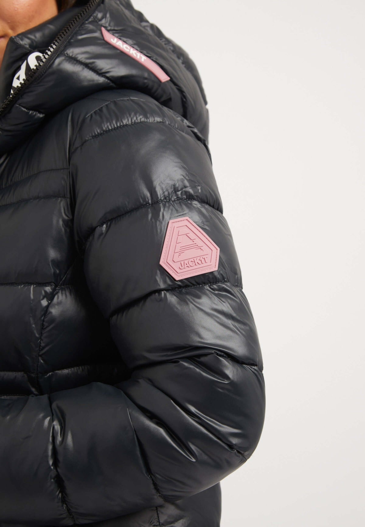 Close-up view of R4D Extra Long Puffer Coat with elasticated cuffs and reflective badge in black.