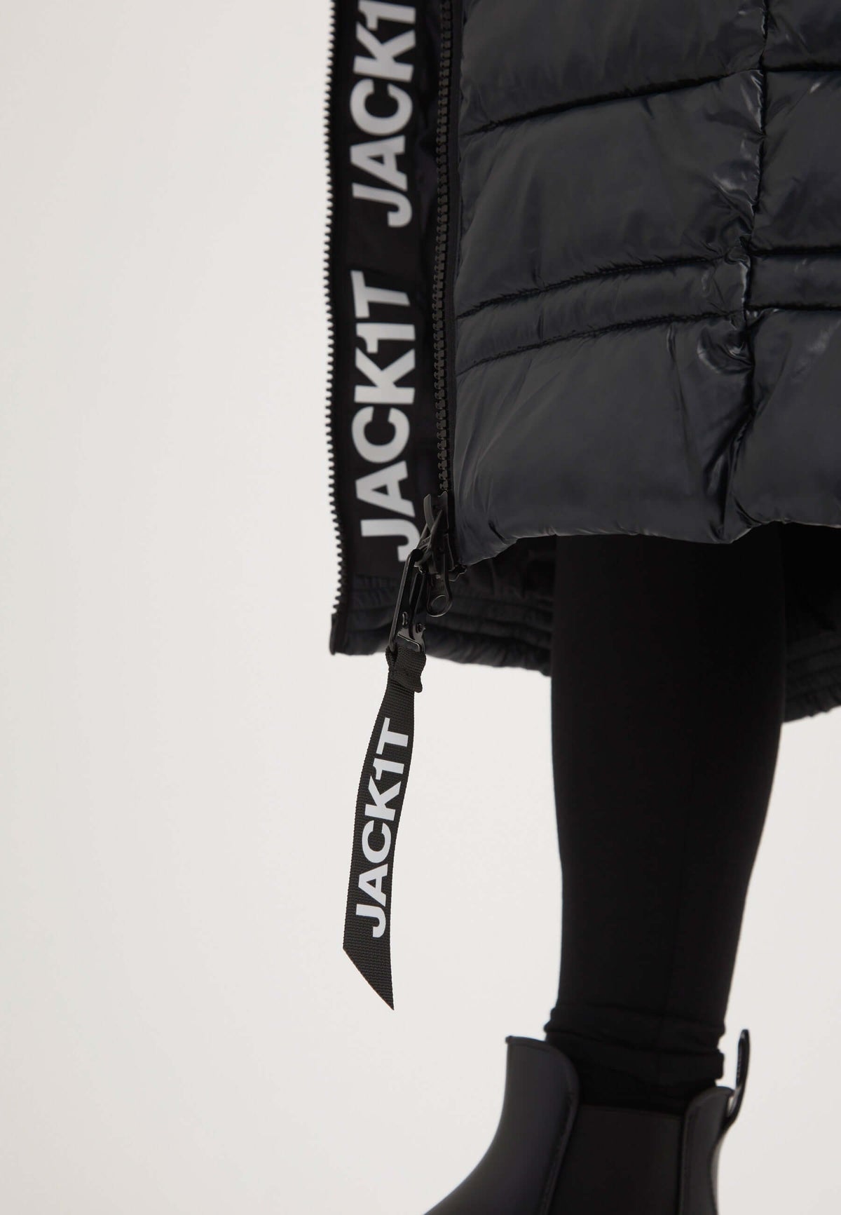 Extra Long Puffer Coat featuring reflective badge and two-way zips, styled with stylish pants for a modern look.