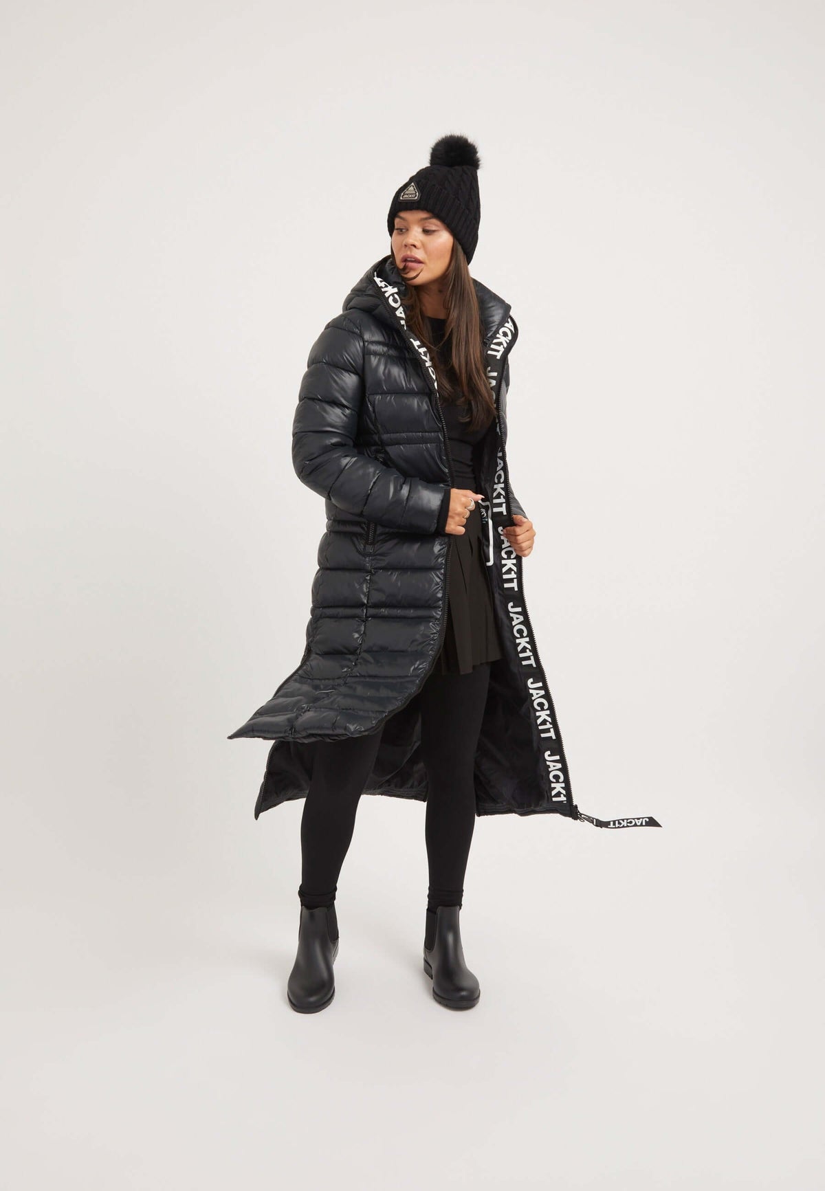 Model wearing R4D Extra Long Straight Baffle Coat Black, showcasing extra long puffer coat with reflective badge and elasticated cuffs.