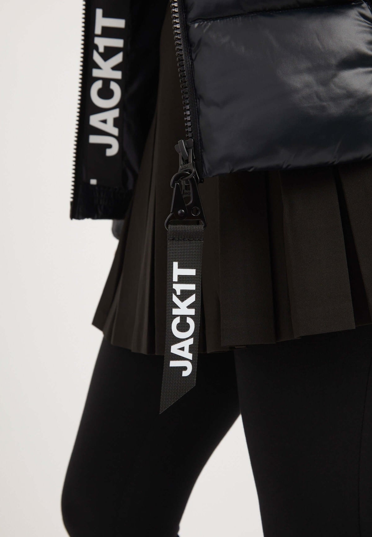 Ladies black puffer jacket with JACK1T branding, showcasing stylish design and elasticated fit.