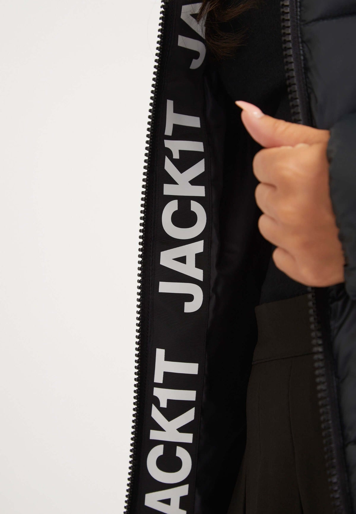Close-up of the interior of a ladies black puffer jacket with branding, showcasing its stylish design and quality.