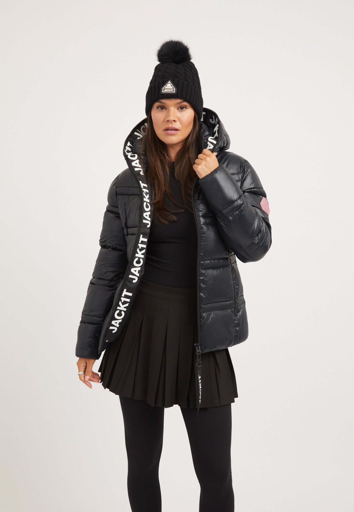 Model wearing R4D Tramline Racer Jacket Black, showcasing ladies black puffer jacket style with stylish beanie and skirt.