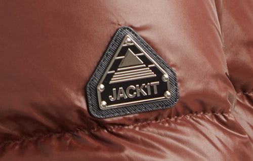 Close-up of the JACK1T logo on a brown padded jacket for branding details.