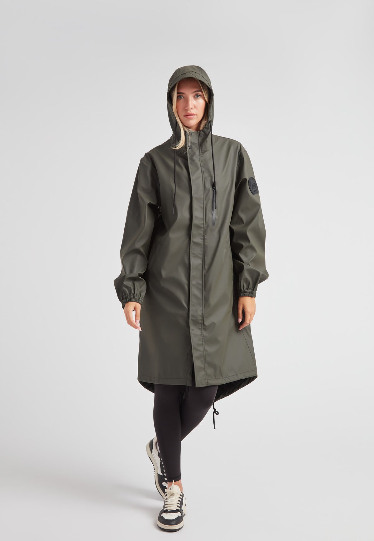 Elements unisex raincoat in khaki worn by a model, showcasing a lightweight, practical design with a hood.