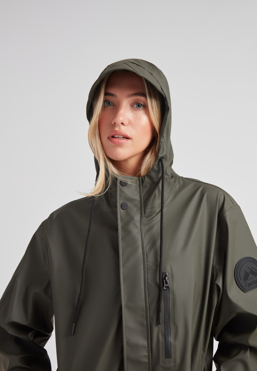 Elements unisex raincoat in khaki worn by a model with a hood, showcasing its lightweight design and style.