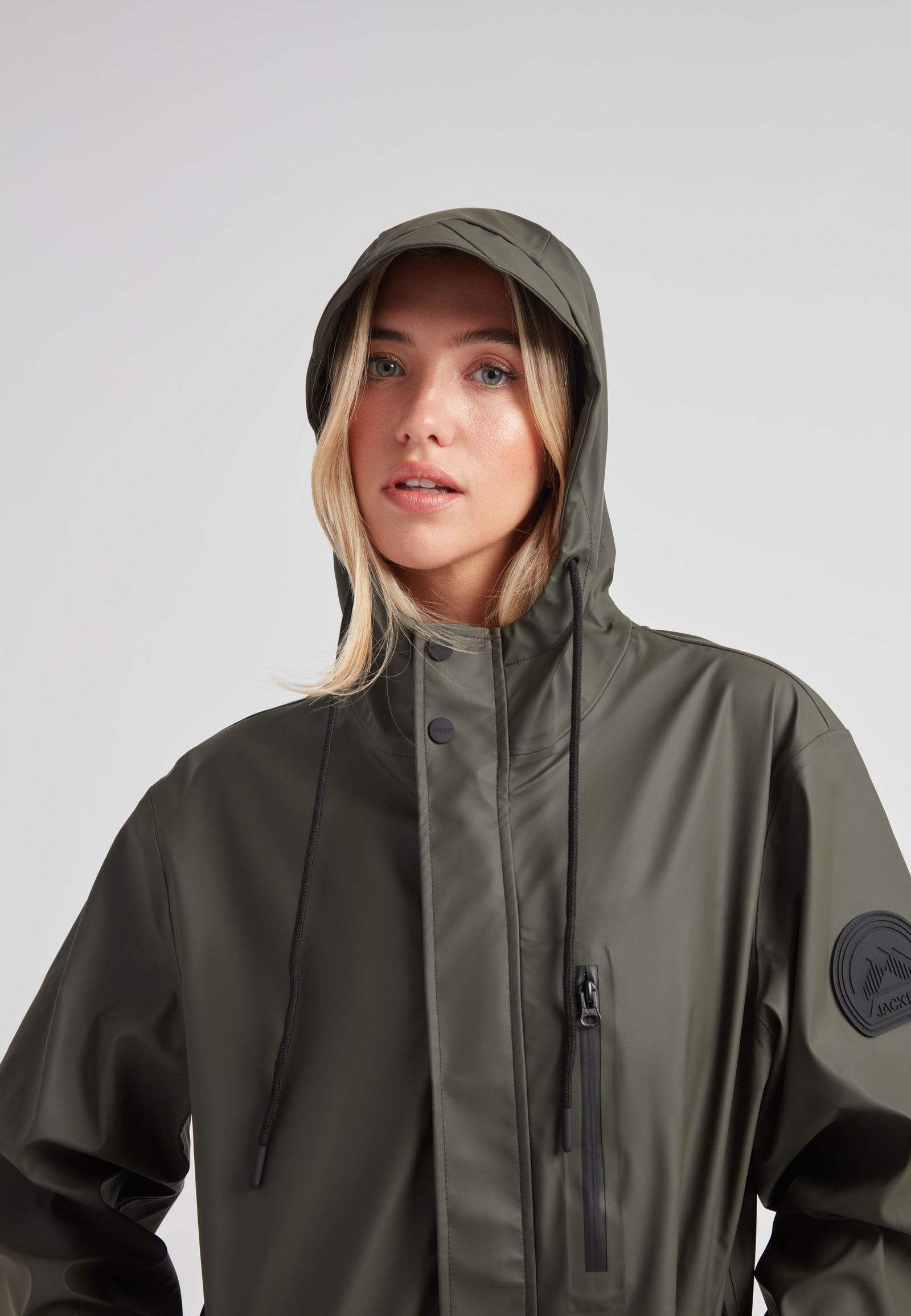 Elements unisex raincoat in khaki worn by a model with a hood, showcasing its lightweight design and style.