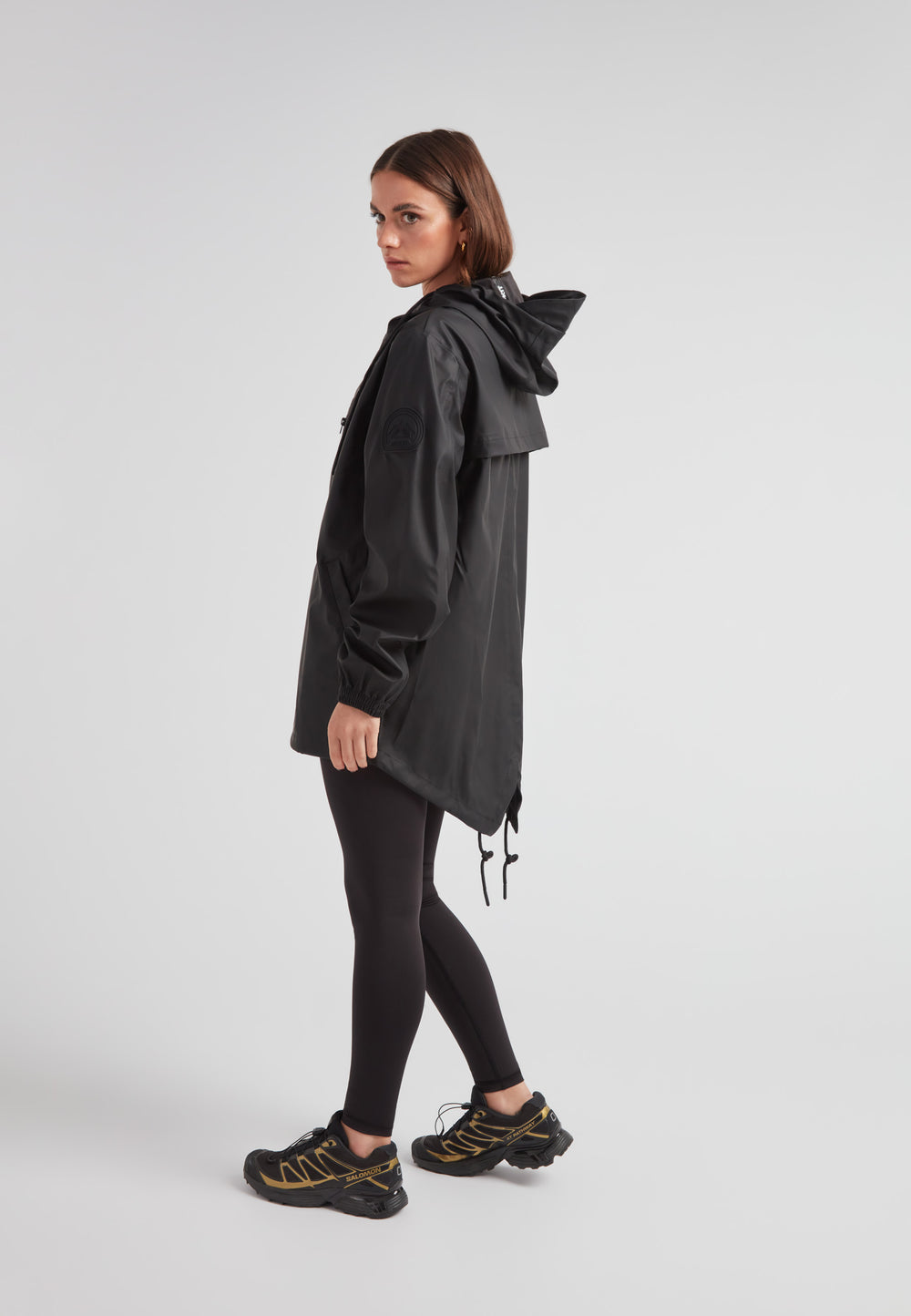 Woman wearing ELEMENTS Raincoat 2.0 Black, showcasing lightweight weather protection and stylish design.