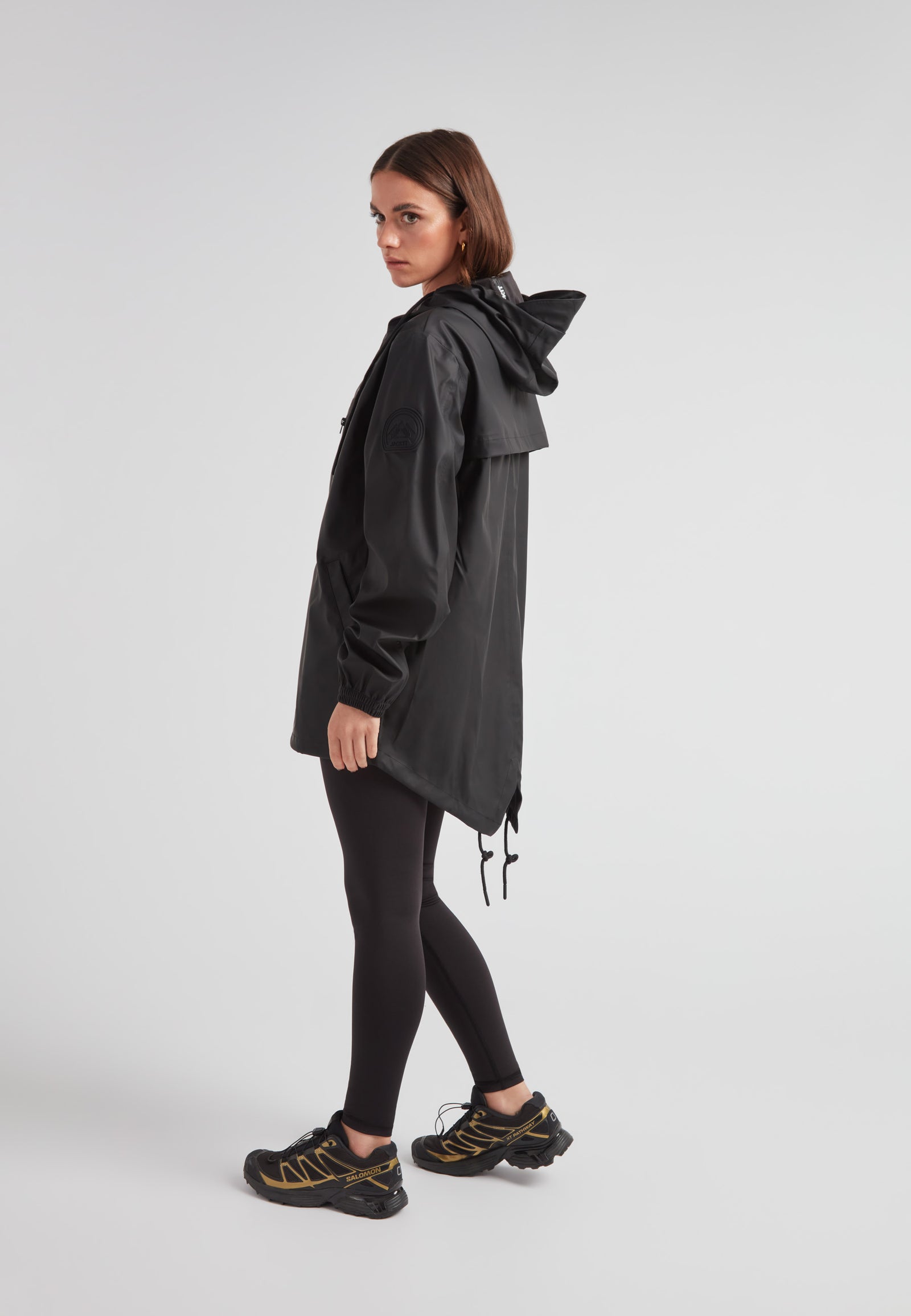 Woman wearing ELEMENTS Raincoat 2.0 Black, showcasing lightweight weather protection and stylish design.