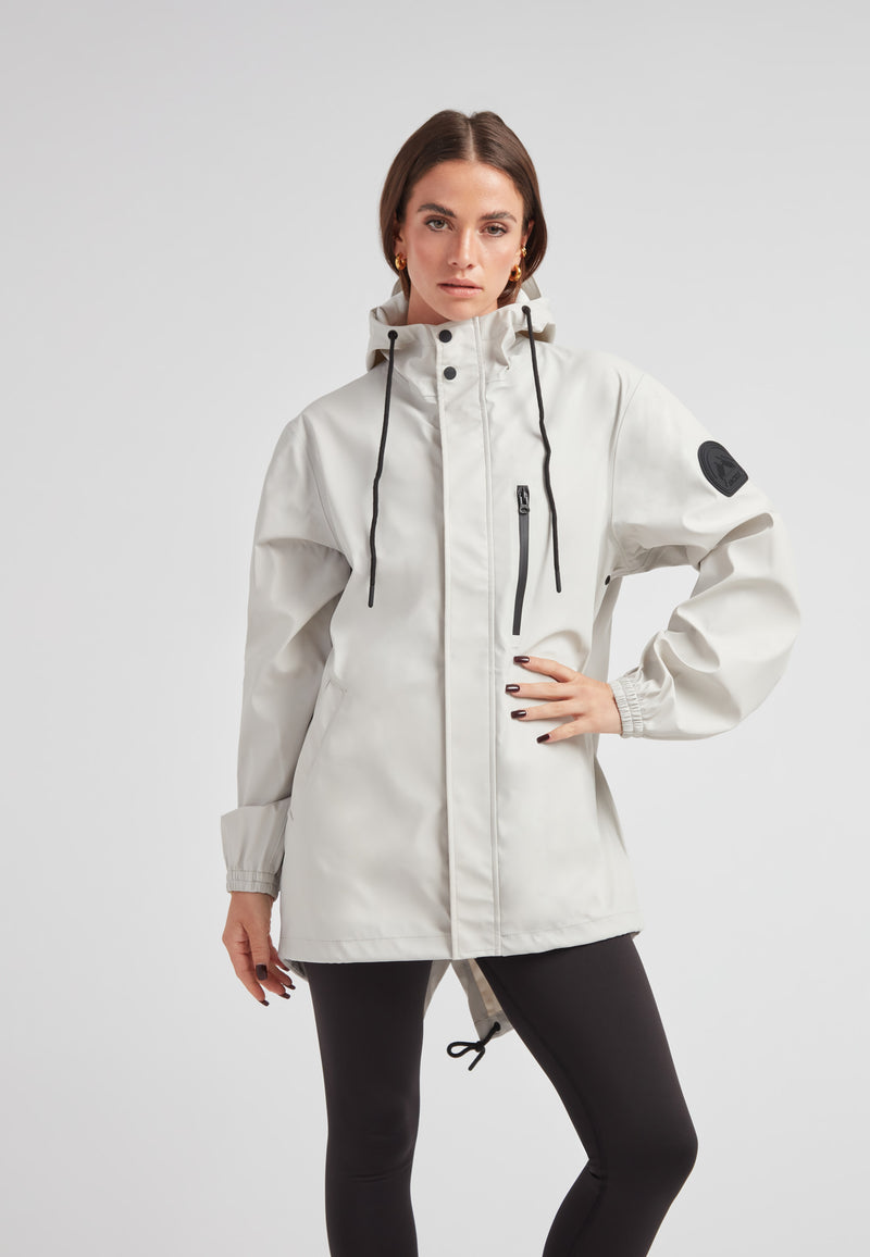 Model wearing the ELEMENTS Raincoat 2.0 Stone, showcasing its lightweight weather protection design.