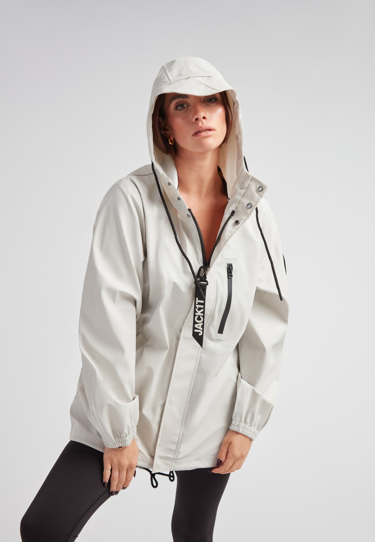 ELEMENTS Raincoat 2.0 Stone worn by a model showcasing lightweight weather protection and stylish design.
