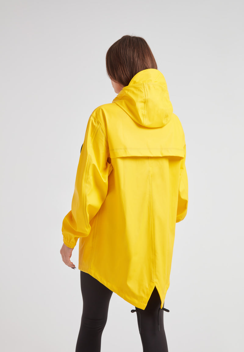 Back view of a woman wearing the ELEMENTS Raincoat 2.0 Yellow with a hood, showcasing its lightweight design.