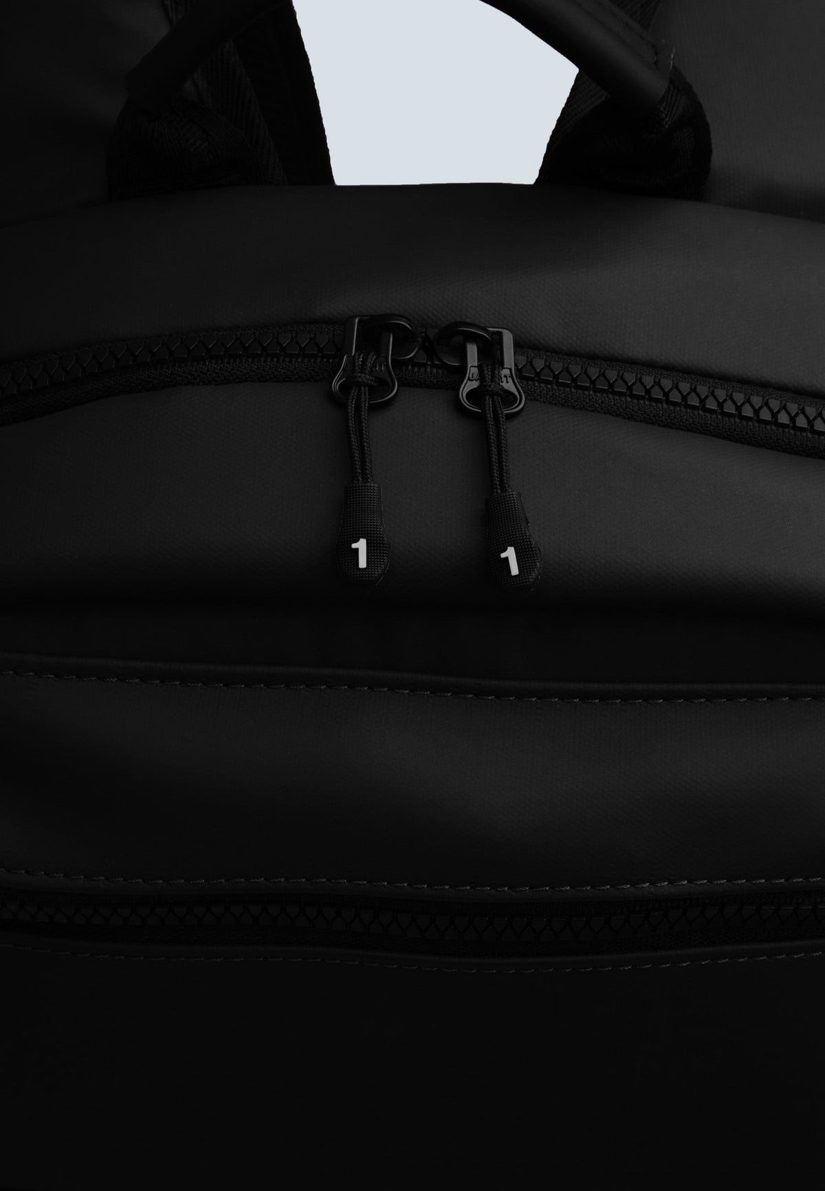 Close-up of JACK1T's black water resistant backpack zipper detail and fabric.