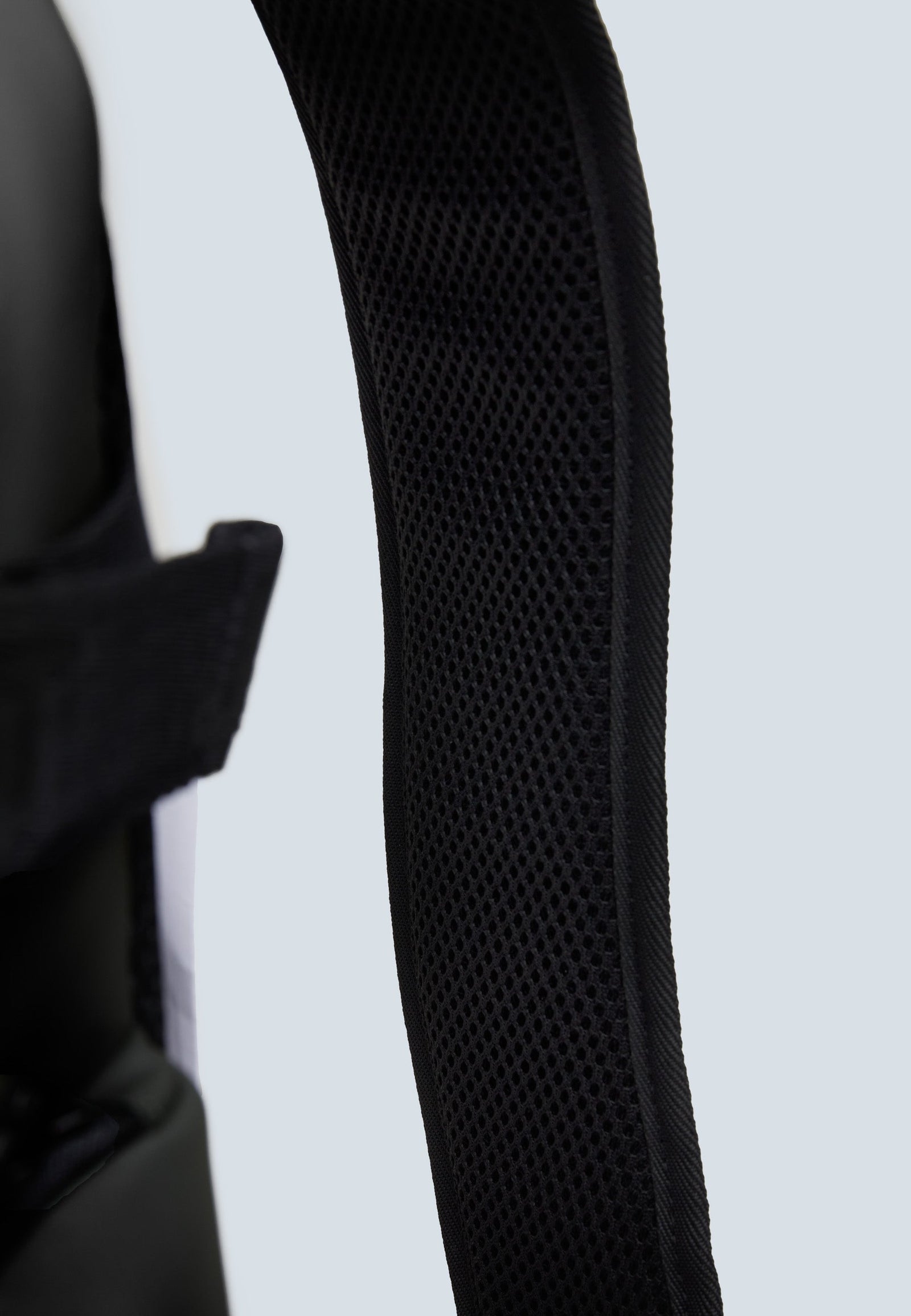 Close-up of JACK1T's black water resistant backpack shoulder strap featuring breathable mesh for comfort.