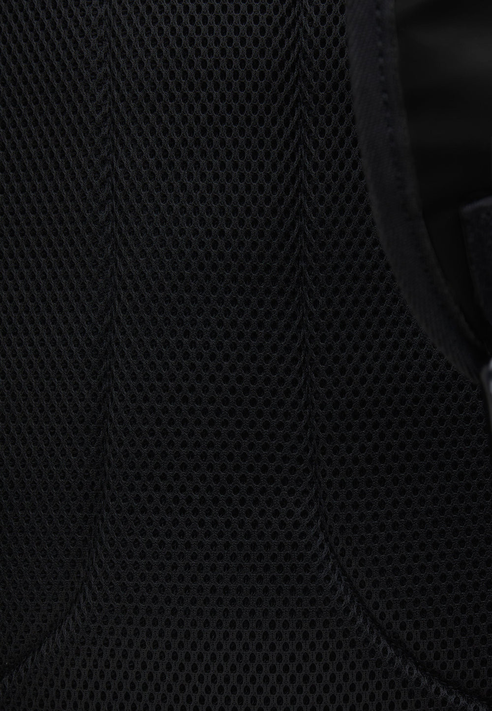 Close-up view of the breathable mesh material on JACK1T's black water resistant backpack.