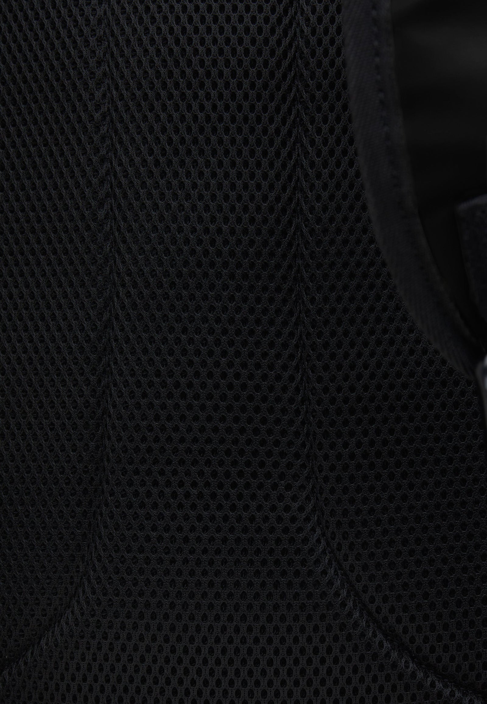 Close-up view of the breathable mesh material on JACK1T's black water resistant backpack.