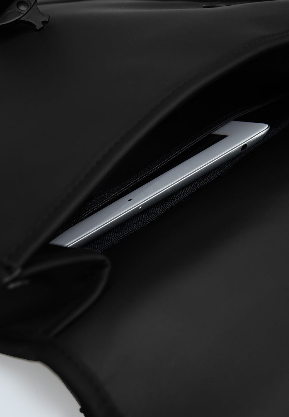 The JACK1T slim messenger laptop bag in black with a laptop securely stored in its compartment.