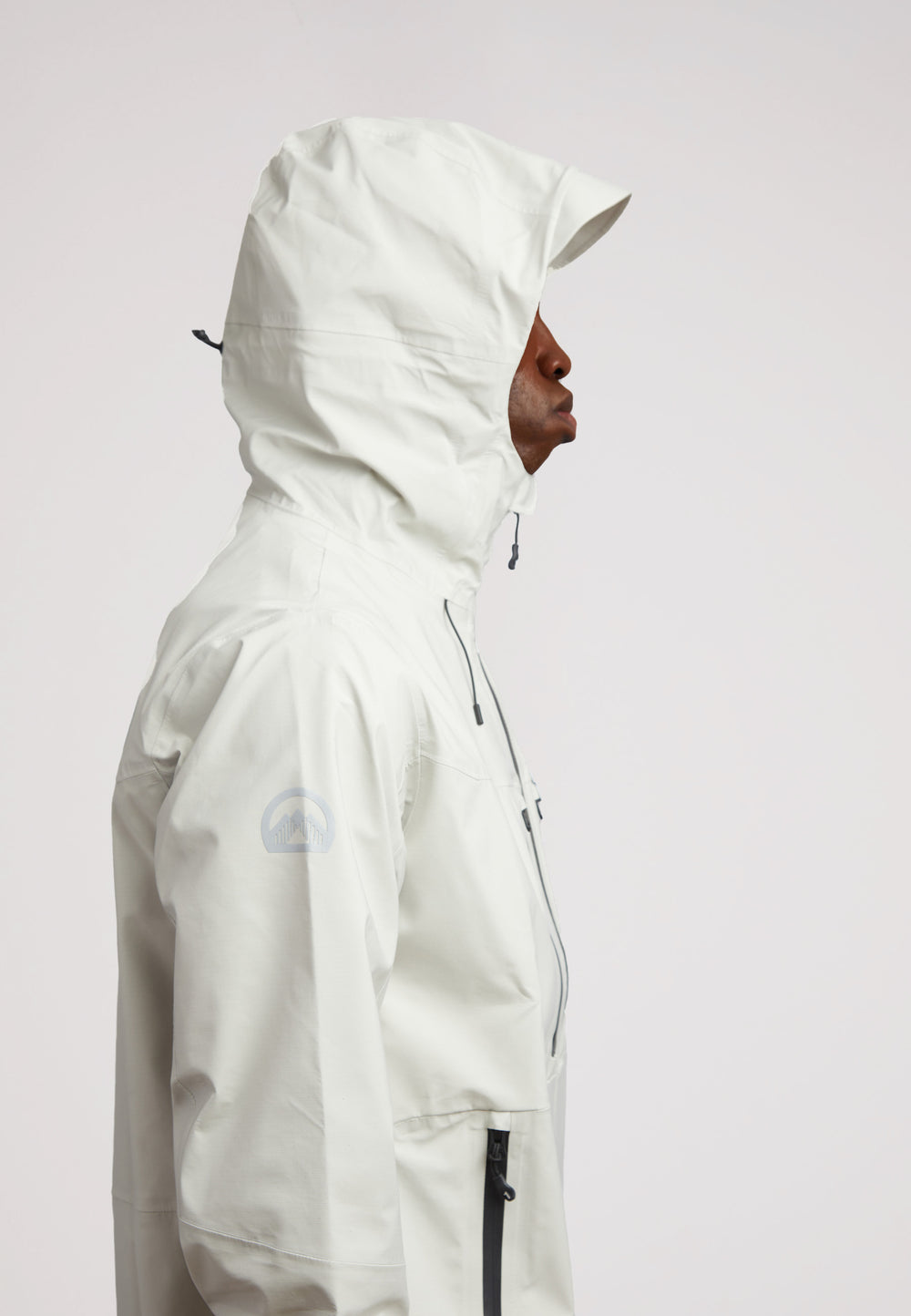 Stone mens lithium waterproof jacket shown from the side, featuring a hood for protection against the elements.