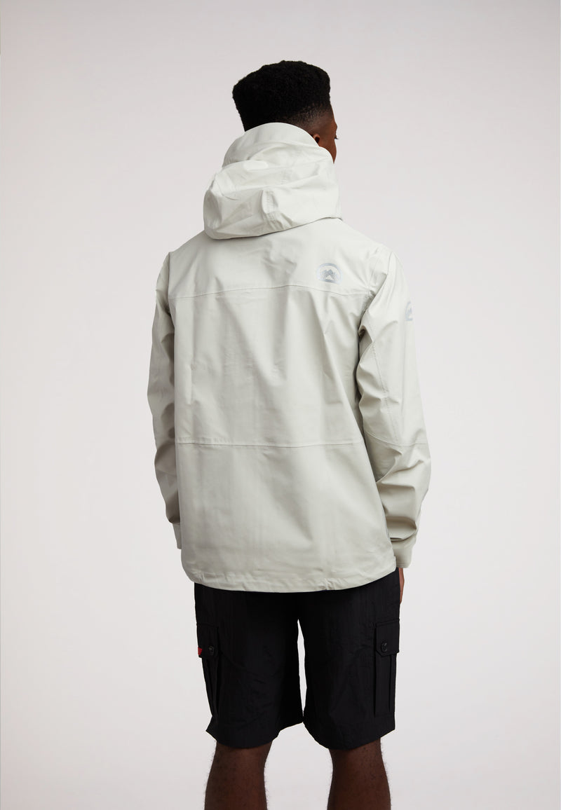 Man wearing the Stone mens lithium waterproof jacket, showcasing its back design and hood.