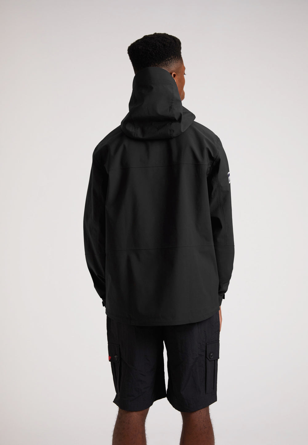 Black mens Lithium waterproof jacket viewed from the back, showcasing the hood and sleek design.