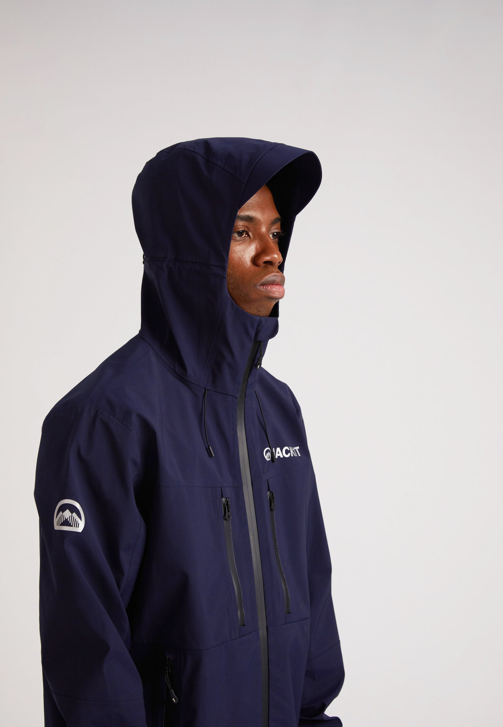 navy lithium waterproof mens jacket worn by a model with the hood up, showcasing its stylish design and functionality.