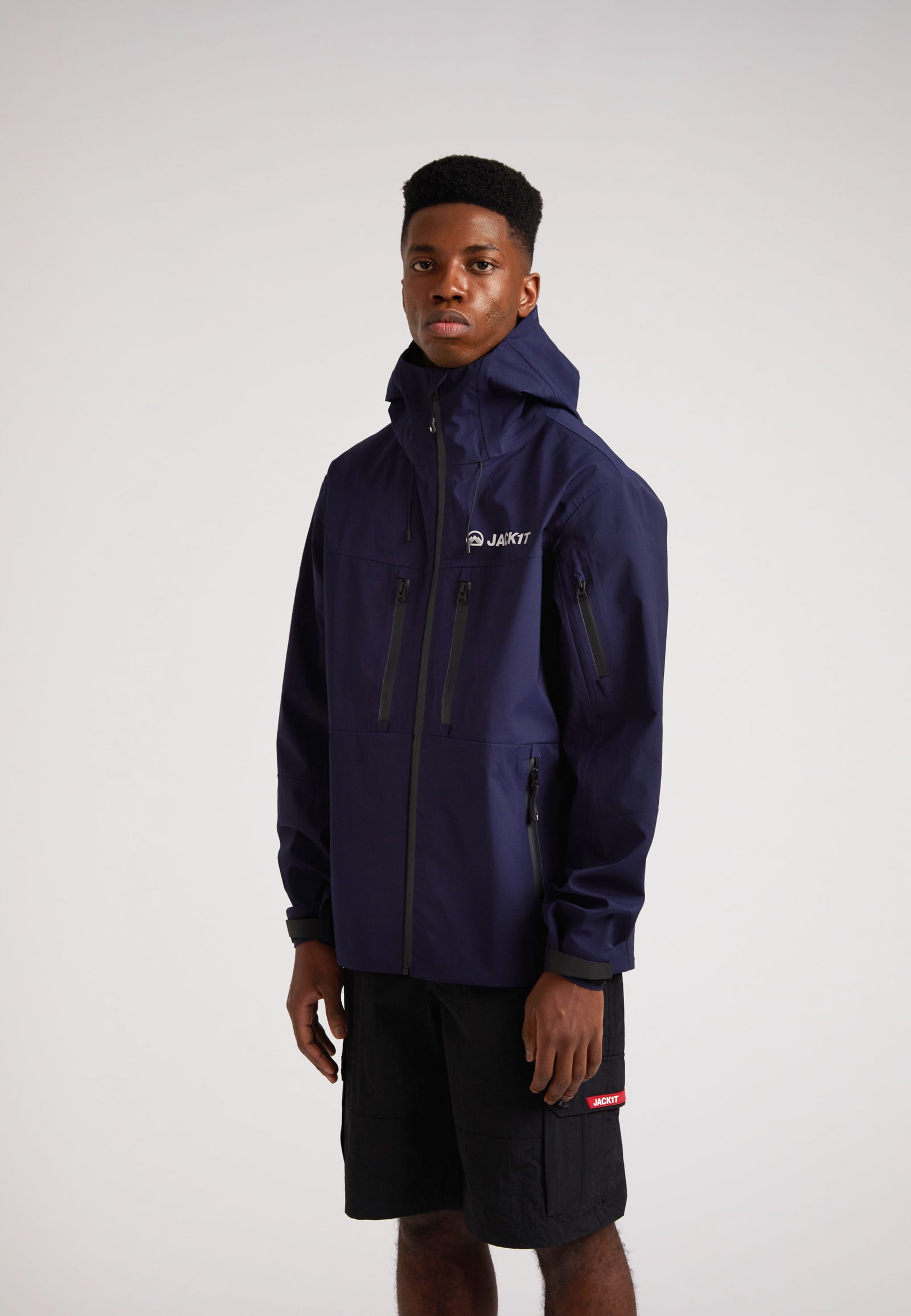 navy lithium waterproof mens jacket modeled by a man in a studio setting, showcasing its design and features.