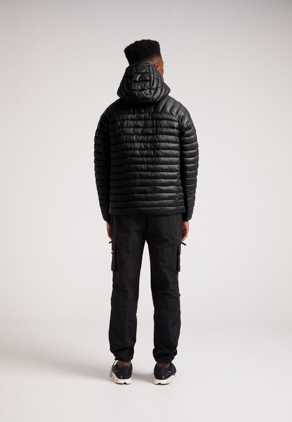 Model wearing SATEL1TE Hooded Jacket 2.0 Black from the back, showcasing its sleek design and hood.