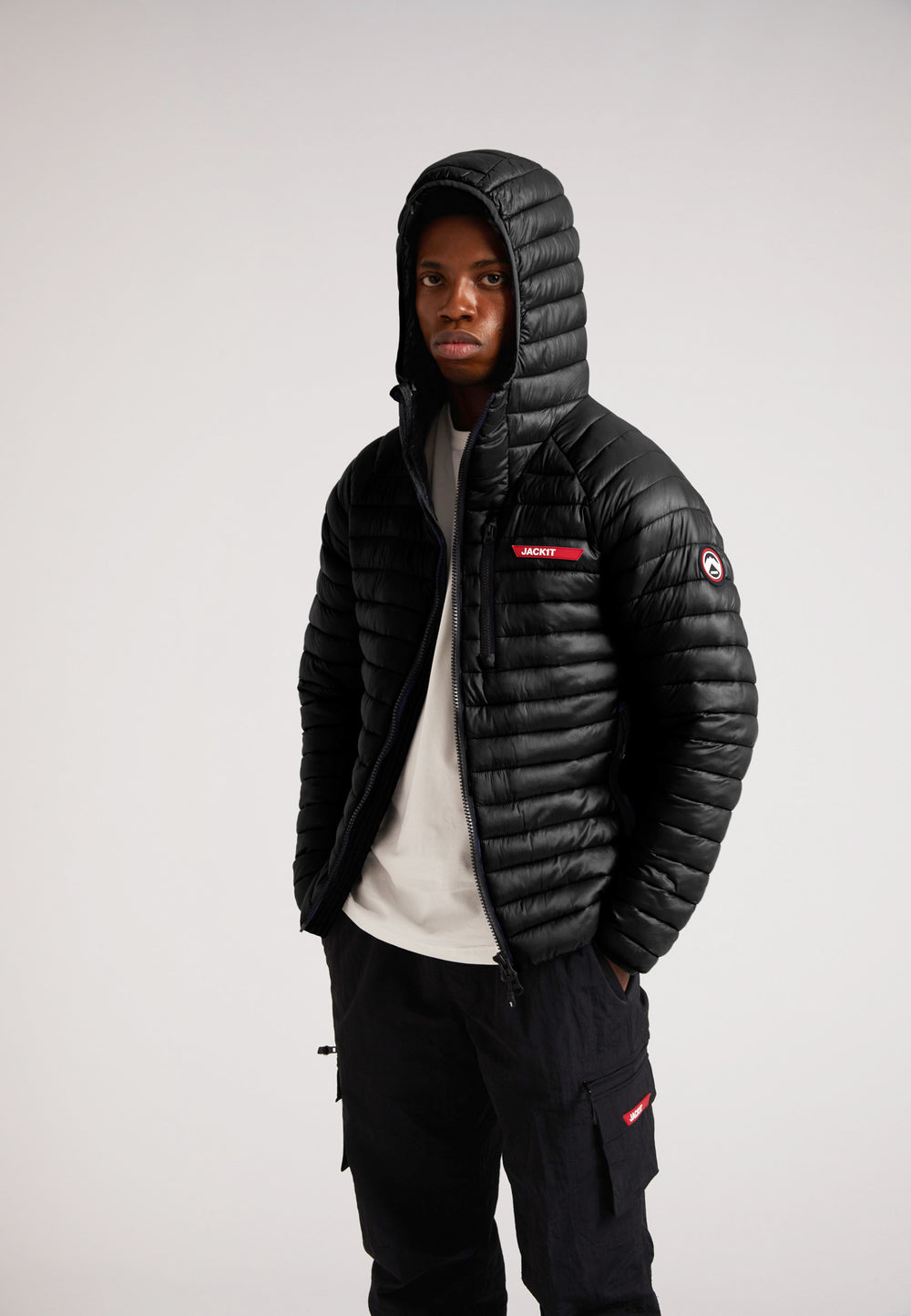 Model wearing SATEL1TE Hooded Jacket 2.0 Black with a hood, showcasing its stylish and versatile design.